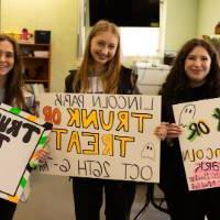 Students holding Trunk or Treat signs